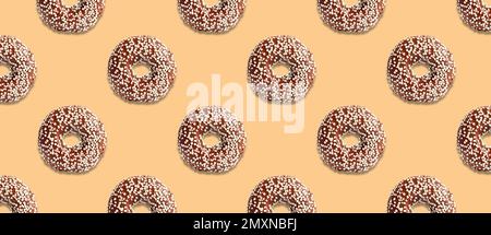Creative pattern design of glazed donuts on pale orange background, banner Stock Photo