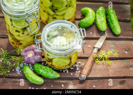 Homemade pickled cucumbers with garlic and dill in greenhouse. Preserved vegetables for the winter. Stock Photo