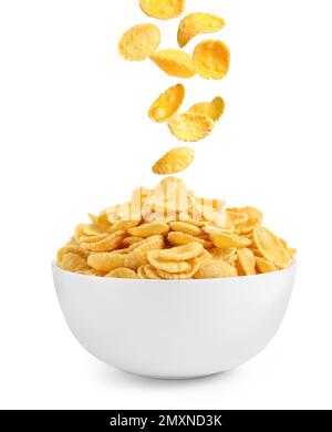 Tasty crispy corn flakes falling into bowl on white background. Breakfast cereal Stock Photo