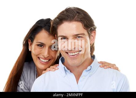 Love, hug and portrait of a couple in a studio for valentines day, romance or anniversary. Happy, smile and young interracial man and woman embracing Stock Photo