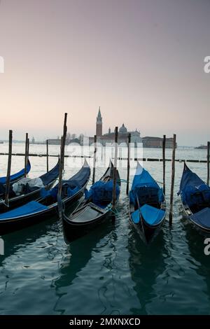 Sunrise from St Marks Square looking across moored gondolas towards San Giorgio Maggiore, Venice, Italy. Stock Photo