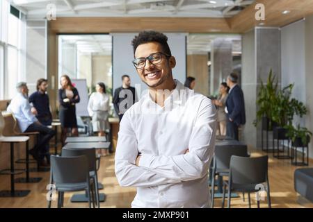 Happy African American business coach standing in office after corporate team training class Stock Photo