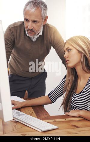 Taking a look at her work. a businessman taking a look at a female colleagues work. Stock Photo