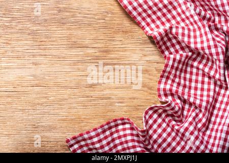 red checkered tablecloth on wooden background, top view Stock Photo
