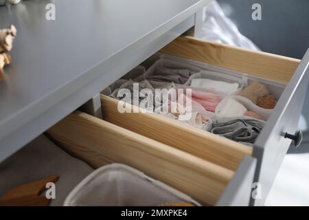 Open cabinet drawer with clothes in child room Stock Photo