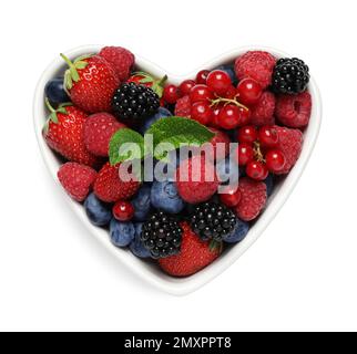 Mix of berries in heart shaped bowl isolated on white, top view Stock Photo