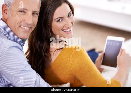 Home is wherever the love is. a happy couple using their digital tablet together. Stock Photo