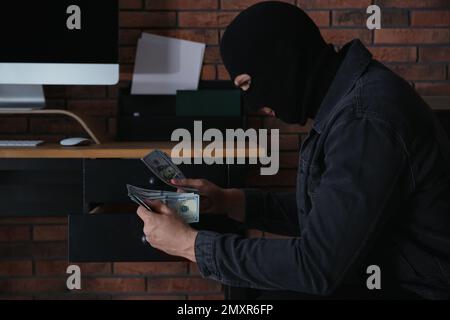 Dangerous masked criminal stealing money from house Stock Photo - Alamy