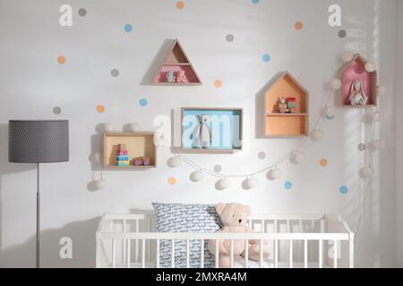 Cute children's room with house shaped shelves and crib. Interior design Stock Photo