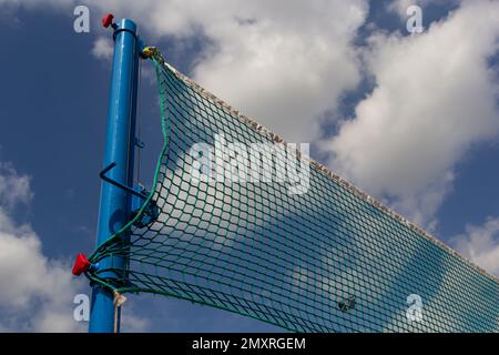 Tennis or volleyball net against blue sky. Beautiful cirrus clouds. Beautiful cirrus clouds over the sports field. Stock Photo