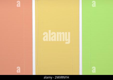 Window with closed multicolor blinds as background Stock Photo