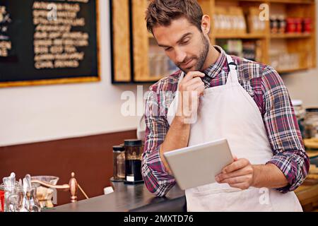 Inventory made easy. a young barista using a digital tablet in a cafe. Stock Photo