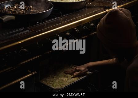 a woman puts a pie in the oven. The pumpkin pie is being prepared. Stock Photo