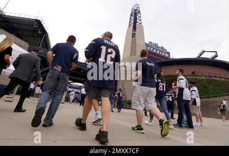 New England Patriots fan Joey Romano, of Scarborough, Maine, climbs the  steps outside Gillette Stadium with his father Paul, wearing the #12 jersey,  prior to an NFL football game, Sunday, Jan. 2