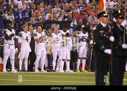 New York Jets players stand as the National Anthem is sung prior