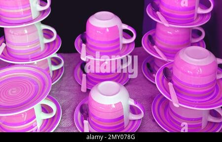 Stacks of cups and saucers in dreamy purple pink color tone Stock Photo