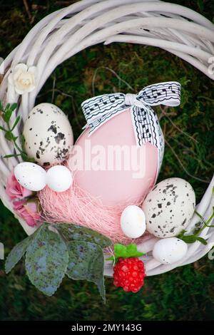 Easter wreath of vines and colored eggs background. Festive decor. Spring holiday decoration. Decorated colorful ster egg. Wreath of branches willow twigs. Stock Photo
