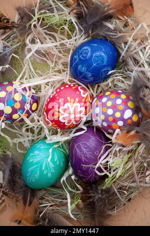 Easter wreath of vines and colored eggs background. Festive decor. Spring holiday decoration. Decorated colorful ster egg. Wreath of branches willow twigs. Stock Photo