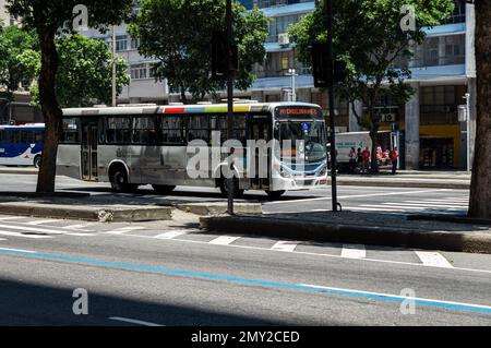 A city bus stopped at a red light on Presidente Vargas avenue nearby the crossing with Uruguaiana street in Centro district in a summer sunny day. Stock Photo