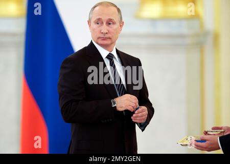 Russian President Vladimir Putin holds an award during an awarding ceremony for Russia's Olympians in Moscow's Kremlin in Moscow, Russia, Thursday, Aug. 25, 2016. (AP Photo/Ivan Sekretarev)