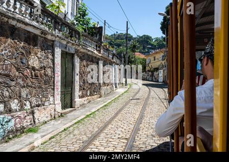 View of cobblestone Joaquim Murtinho street during a ride on Santa Teresa tramway in Santa Teresa district under summer afternoon sunny clear blue sky Stock Photo