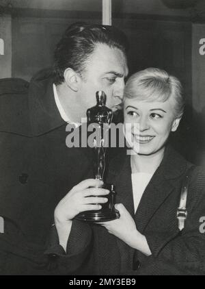 Italian filmmaker Federico Fellini and actress Giulietta Masina receiving the Academy Award, USA 1957 Stock Photo