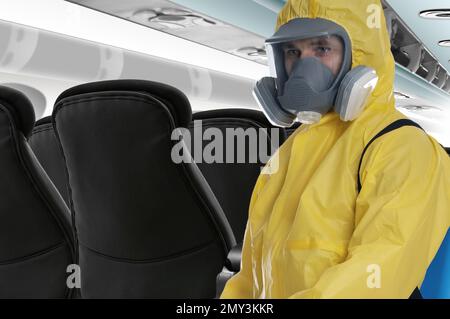 Man wearing protective suit cleaning cabin in airplane to prevent spreading of Coronavirus Stock Photo