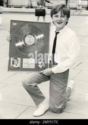 Welsh choirboy Aled Jones holding a silver disc award to mark the sales of the album Voices from the Holy Land, UK 1980s Stock Photo