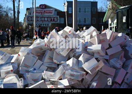 Raleigh, NC, USA, 4th February 2023, A pile of empty Krispy Kreme doughnuts boxes lay in the street at the half way point of a 5-mile sprint from the North Carolina State University campus. First run in 2004 as a dare among friends, the annual Krispy Kreme Challenge quickly became a fundraiser benefiting the UNC Children’s Hospital. The course record of 28:29 was set in 2020 with a pace of 5:41/mile, which includes time eating doughnuts. With national exposure the motto is “2,400 calories, 12 doughnuts, 5-miles, 1 hour.” Credit D Guest Smith / Alamy Live News Stock Photo