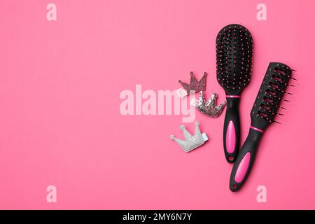 Flat lay composition with modern hair brushes on pink background, space for text Stock Photo