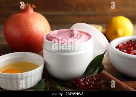 Natural homemade mask, pomegranate and ingredients on wooden table, closeup Stock Photo