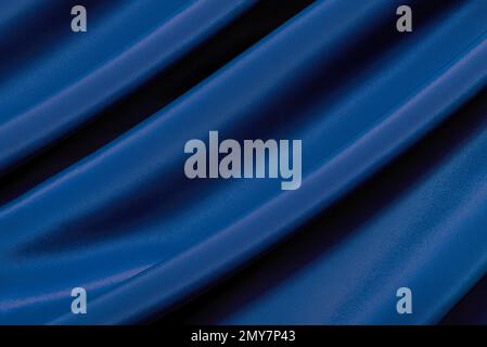 The texture of a luxurious smooth fabric in blue, purple with folds and waves. Blue fabric, material Stock Photo