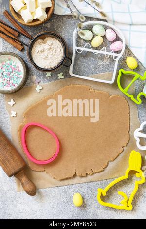 Easter baking ingredients background. Flour, eggs, milk, sugar, butter and kitchen utensils for baking on a stone table. View from above. Copy space. Stock Photo
