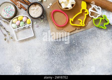 Easter baking ingredients background. Flour, eggs, milk, sugar, butter and kitchen utensils for baking on a stone table. View from above. Copy space. Stock Photo