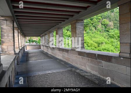 Columns on the pedestrian path on the Edersee dam in Germany with a view of the green forest Stock Photo