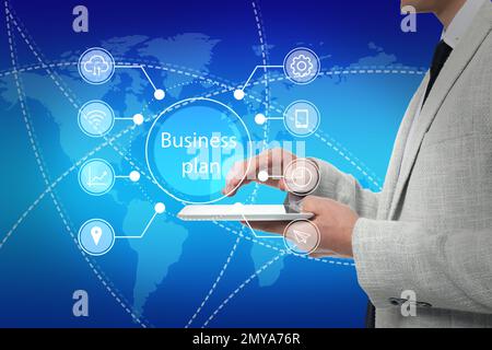 Business plan. Virtual screen with different icons and man using tablet , closeup Stock Photo