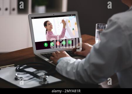 Doctor having online video consultation with business trainer at table, closeup Stock Photo