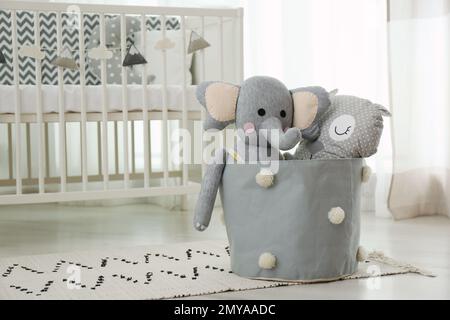 Adorable toys on floor in nursery. Stylish interior element Stock Photo