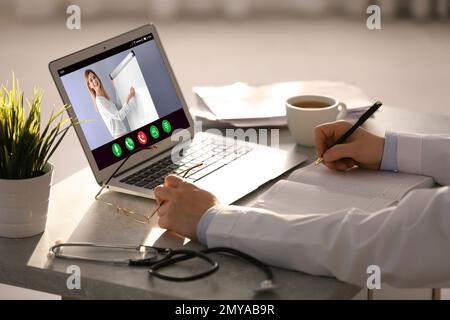 Doctor having online video consultation with business trainer at table, closeup Stock Photo