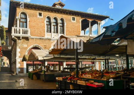 The fruit and vegetable market of Rialto uncrowded in the early morning with the Loggia of the Fish Market, sestiere of San Polo, Venice, Italy Stock Photo