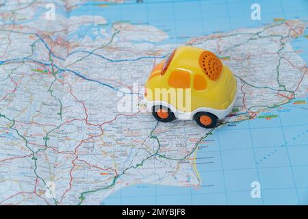 A toy car placed on a map to suggest a journey or road trip Stock Photo