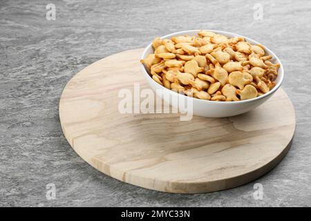 Delicious goldfish crackers in bowl on table Stock Photo