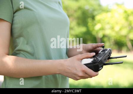 Woman holding new modern drone controller outdoors, closeup of hands Stock Photo