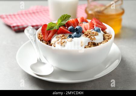 Tasty granola with yogurt and berries served for breakfast on light table Stock Photo