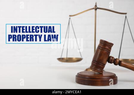 Text Intellectual Property Law near judge's gavel and scales of justice on table against white background Stock Photo