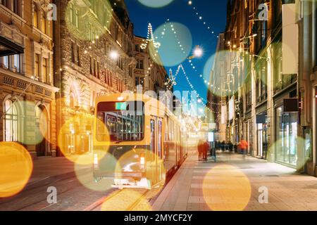 Helsinki, Finland. Effect Bokeh Tram Departs From Stop On Aleksanterinkatu Street. Evening Christmas Xmas New Year Festive Illumination. Boke View Stock Photo