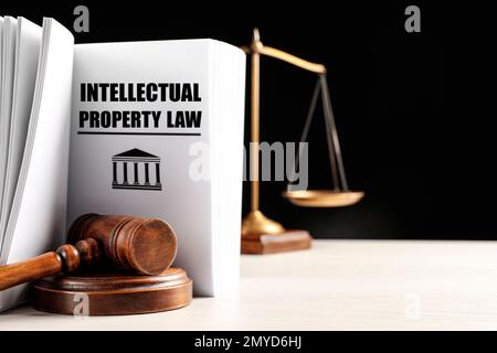 Intellectual Property law book, judge's gavel and scales of justice on white table against black background. Space for text Stock Photo