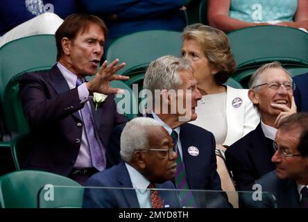 Singer Sir Cliff Richard, left, and former news reader Sir Trevor McDonald, front centre, sit in the Royal Box during day five of the Wimbledon Tennis Championships in London, Friday, July 1, 2016. (AP Photo/Ben Curtis)