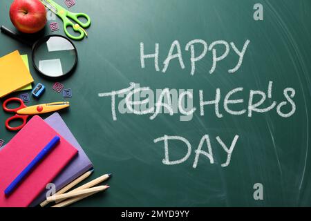Text Happy Teacher's Day and different school stationery on green chalkboard, flat lay. Greeting card design Stock Photo