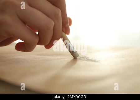 Woman correcting picture on paper with pencil eraser, closeup Stock Photo